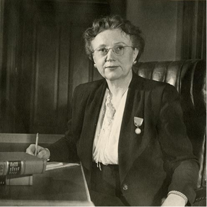Black and white photo of a woman sitting at a desk